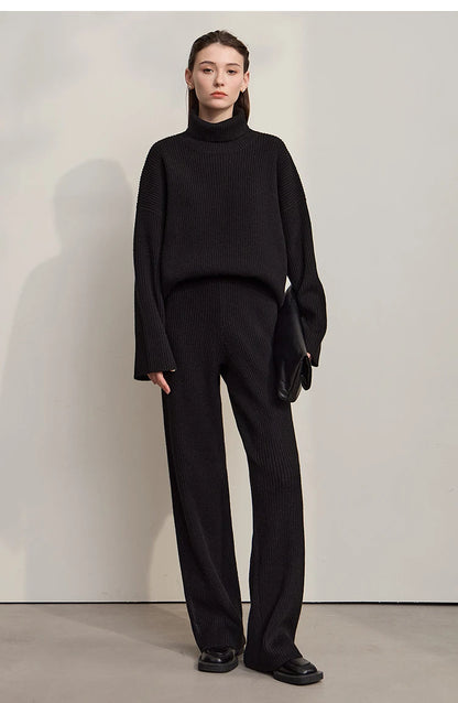 Schwarzer Rollkragenpullover mit langen Ärmeln, dazu schwarze weite Hose