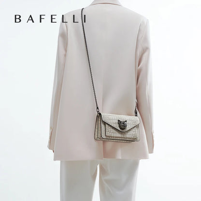 Echtleder-Crossbody-Clutch in Chalk am Kettenriemen getragen, Rückenansicht