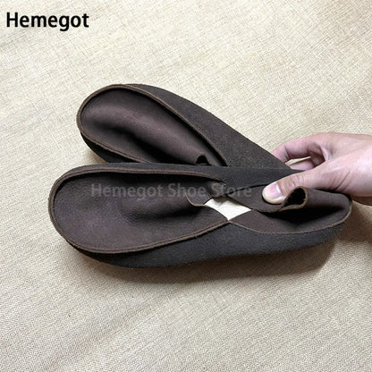 Dunkle Lederschlupf-Loafer mit weicher Sohle, Hand zeigt Einstieg