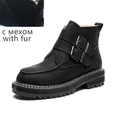 Schwarze Stiefelette mit Fellbesatz am Schaft, Schnalle und robuster Profilsohle