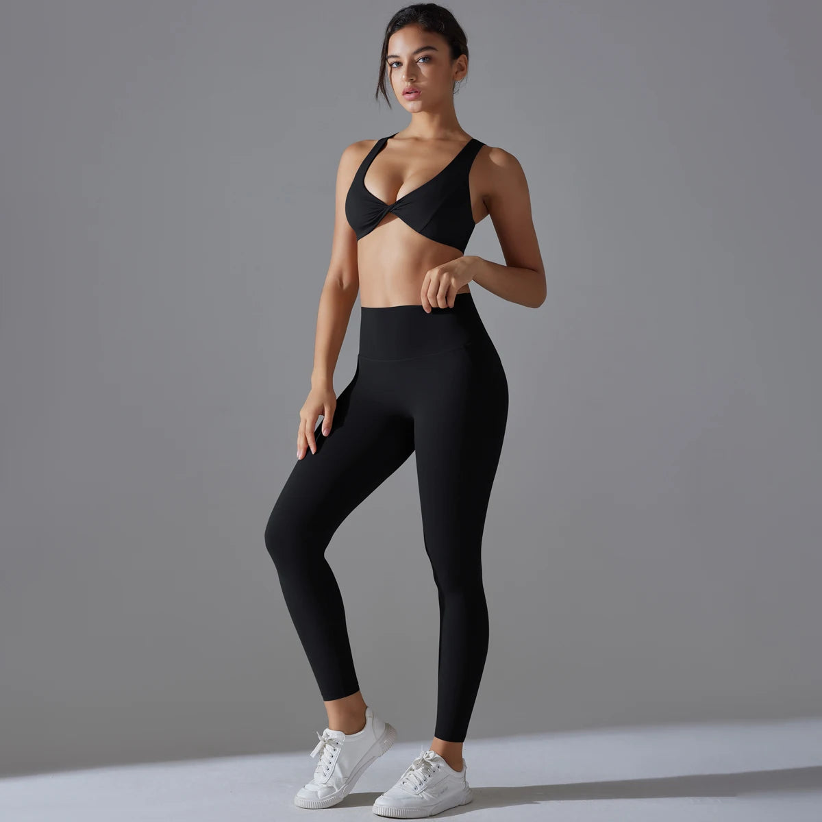 Damen-Yoga-Set in Schwarz mit Sport-BH und Leggings, Vorderansicht im Stand