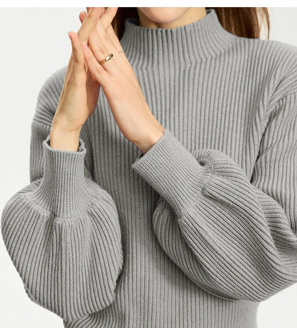 Grau melierter Wollpullover im Detail: Stehkragen, Rippenstrick und weite Ärmelbündchen
