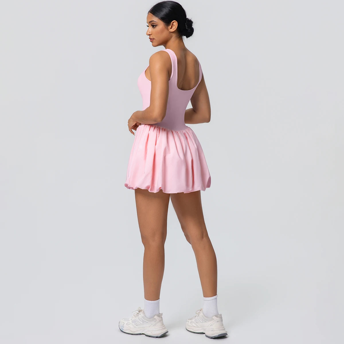 Damen-Tennisrock mit Taschen, rosa Faltenrock, Rückansicht mit kurzem Saum.
