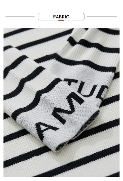 Strickstoff mit schwarz-weißen Streifen und eingestricktem Schriftzug „AMII“.