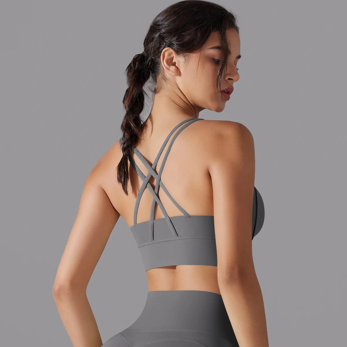 Rückenansicht Yoga-Top mit Brustsupport, gekreuzte Träger, graues Sportmaterial