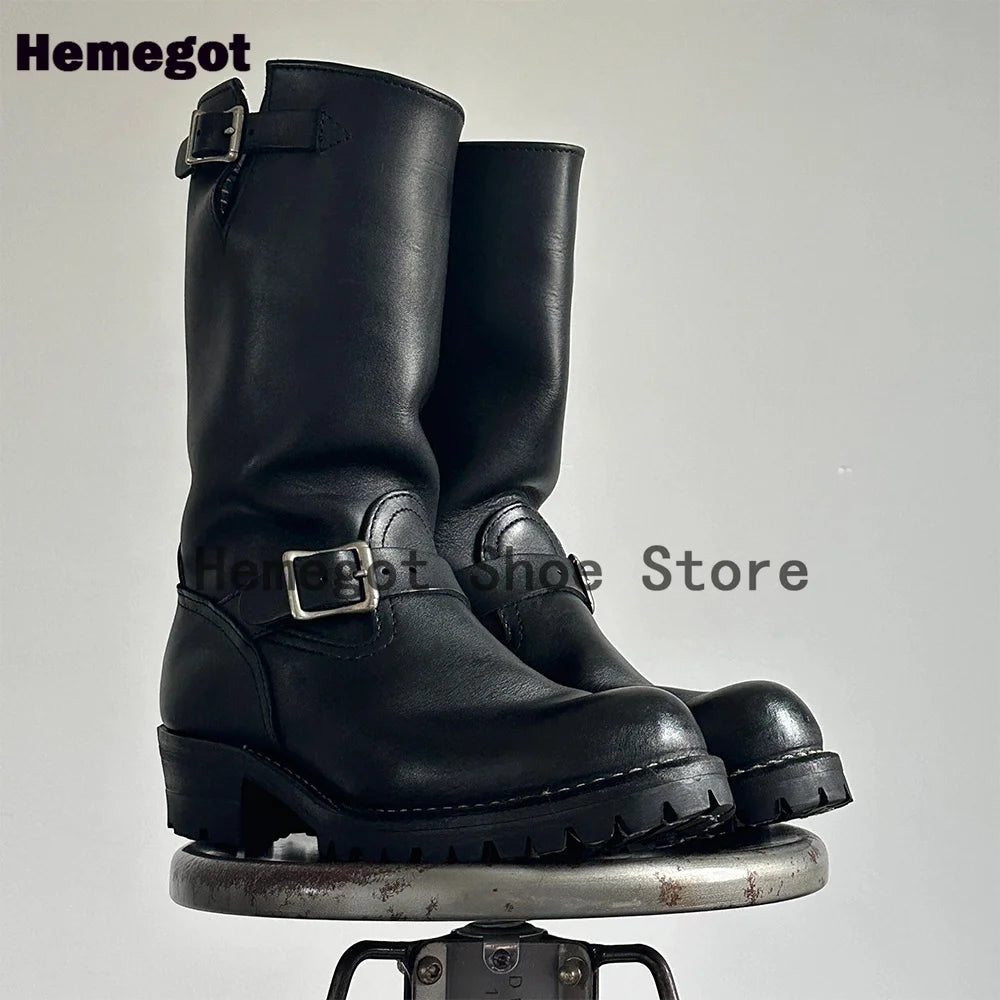 Paar schwarze Stiefel mit Schnallenriemen und grober Profilsohle, Frontansicht
