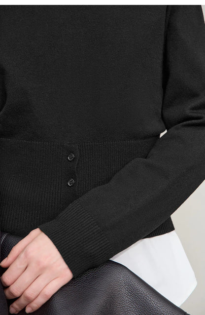 Nahaufnahme: Schwarzer Strickpullover mit Knöpfen am Saum und gerippten Bündchen
