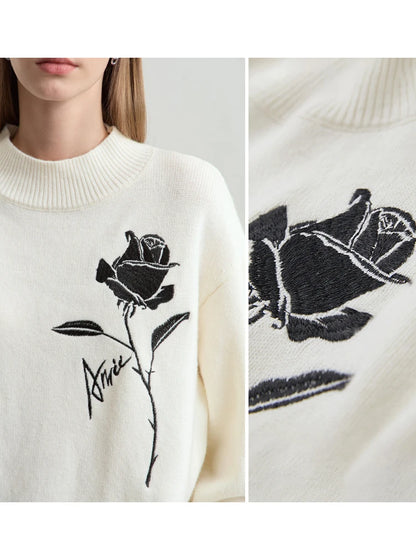 Nahtloser Strickpullover: Detailansicht der schwarzen Rosenstickerei auf offwhite Stoff