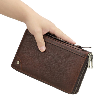 Braune Leder-Clutch-Geldbörse in der Hand, glatte Vorderseite mit Reißverschluss