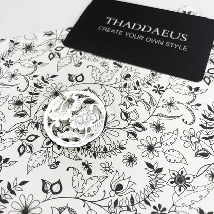 Runder Anhänger aus Sterlingsilber mit Blumenrelief, auf weißer Schmuckverpackung