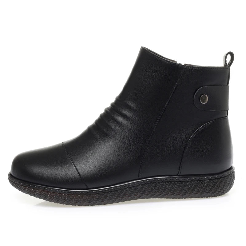 Schwarzer Kurzstiefel aus Leder, flache Profilsohle, seitlicher Riemen und Öse