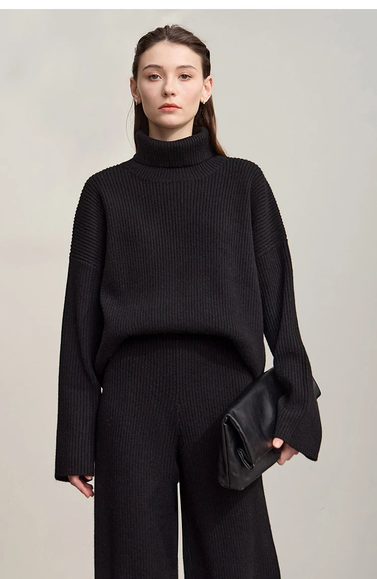 Schwarzer Rollkragenpullover mit langen Ärmeln, dazu schwarze weite Hose