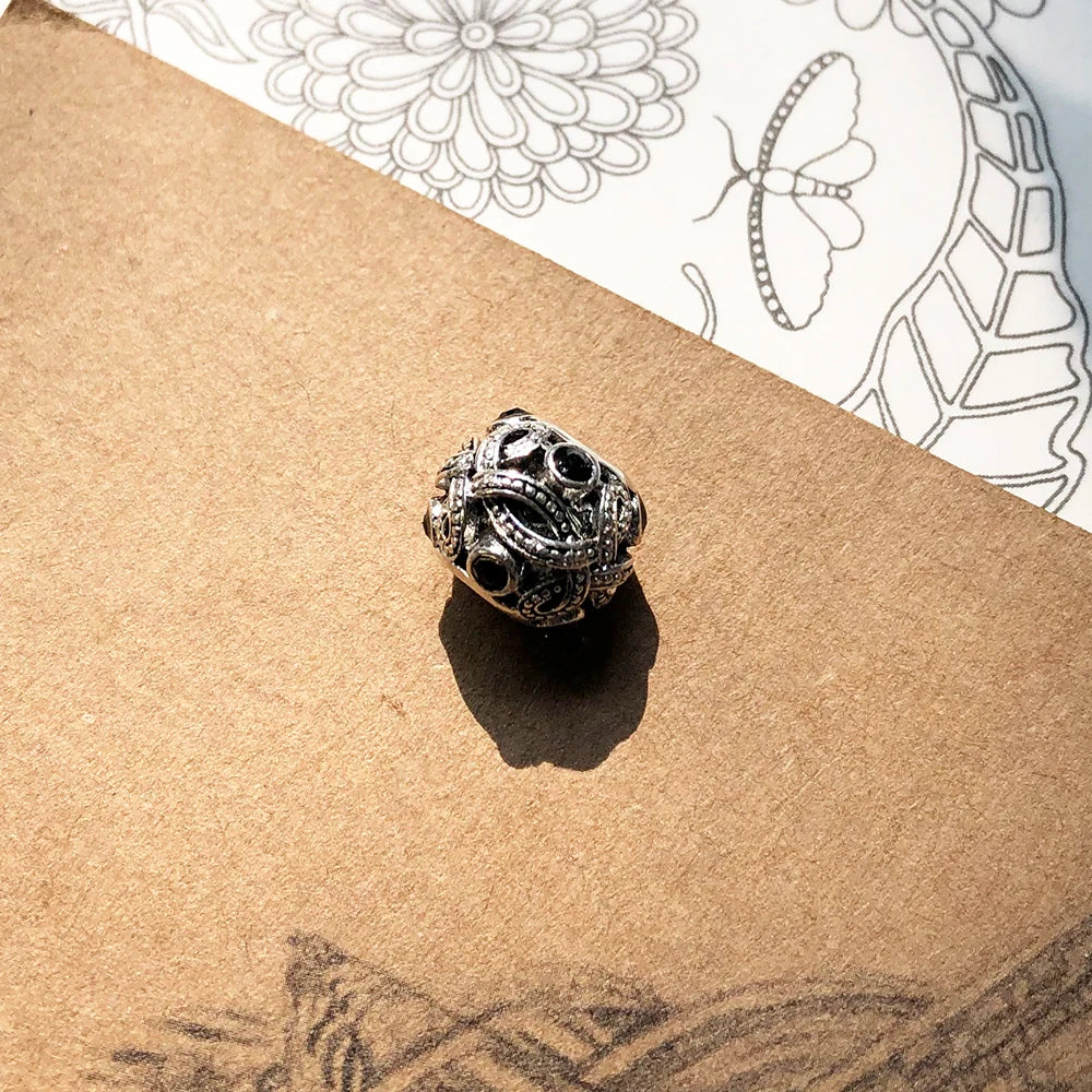 Schmuckperle mit schwarzem Ornament-Liebesknoten und detaillierter Gravur