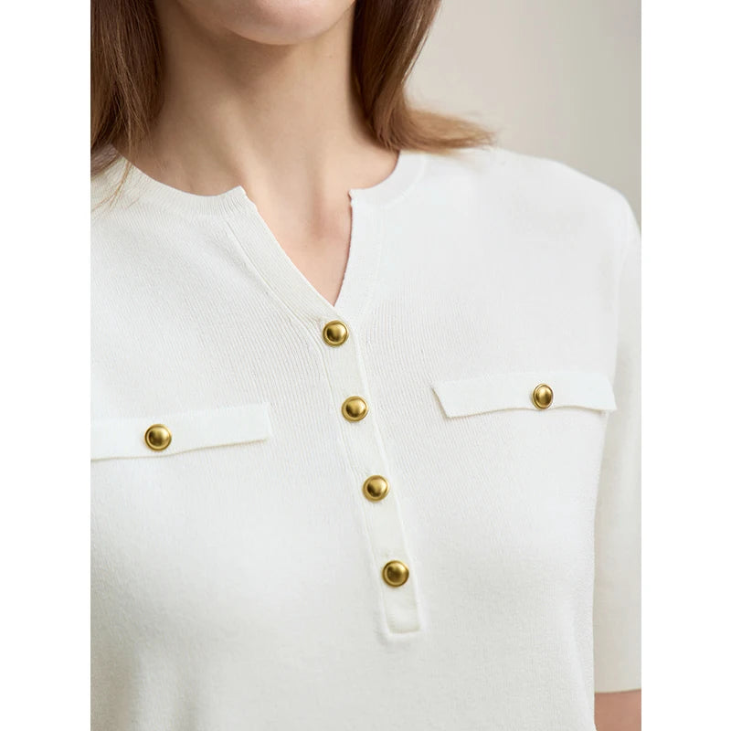 Nahaufnahme: weißer Strickpullover mit V-Ausschnitt, goldenen Knöpfen und Brusttaschen