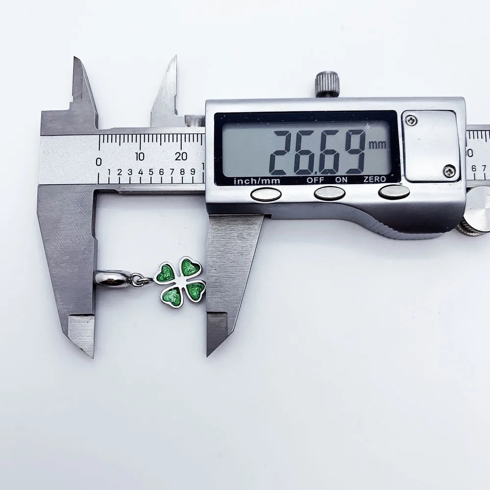 Grüner Kleeblatt-Charm-Anhänger aus 925er Sterlingsilber neben Messschieber
