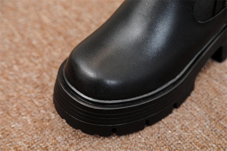 Schwarzer Stiefel mit glattem Obermaterial und dicker, geriffelter Profilsohle