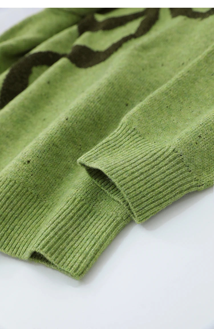 Grüner Strickpullover mit geripptem Bündchen und schwarzem Jacquard-Detail