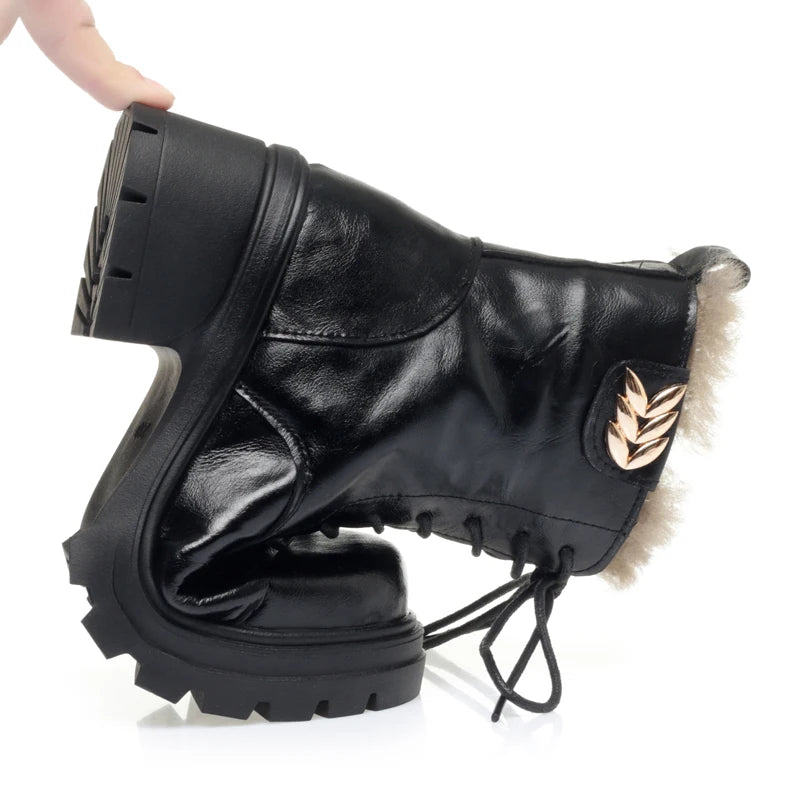 Damenstiefelette in Schwarz mit Schnürung, Kunstfellsaum und goldfarbenem Emblem, grobe Sohle
