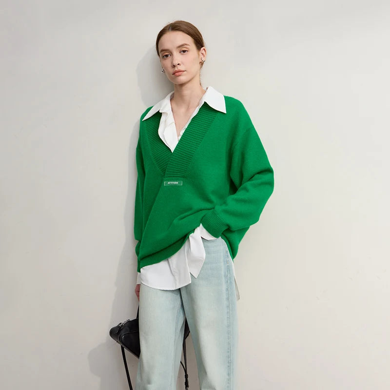 Grüner Strickpullover mit V-Ausschnitt, weißem Hemdkragen darunter, lange Ärmel.