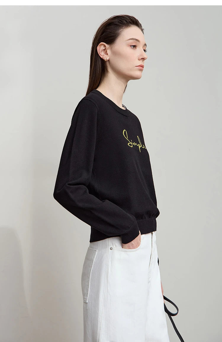 Schwarzes Langarm-T-Shirt mit kleinem Schriftzug, seitliche Ansicht, Rundhalsausschnitt