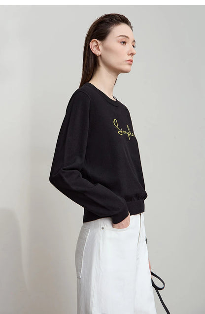 Schwarzes Langarm-T-Shirt mit kleinem Schriftzug, seitliche Ansicht, Rundhalsausschnitt