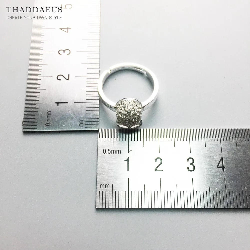 Totenkopf-Ring mit Größenmessung am Lineal, silberfarbenes Band und strukturierter Kopf