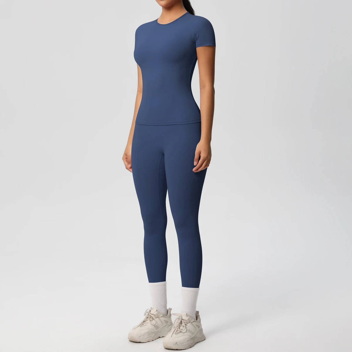 Blaues Sport-Set aus Crop-Top und Leggings, körpernah geschnitten, 3/4-Länge, weißer Abschluss.
