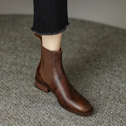 Chelsea-Boots Damen, braune Stiefeletten auf Teppich, rutschfeste Profilsohle sichtbar