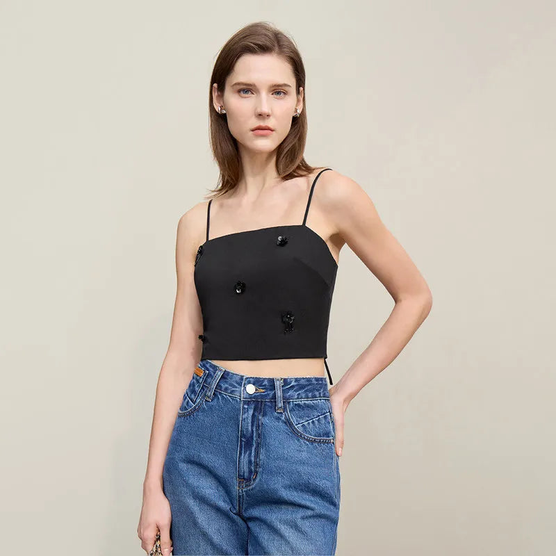 Schwarzes Träger-Top mit Knopf- und Schmuckapplikationen, dazu Jeans