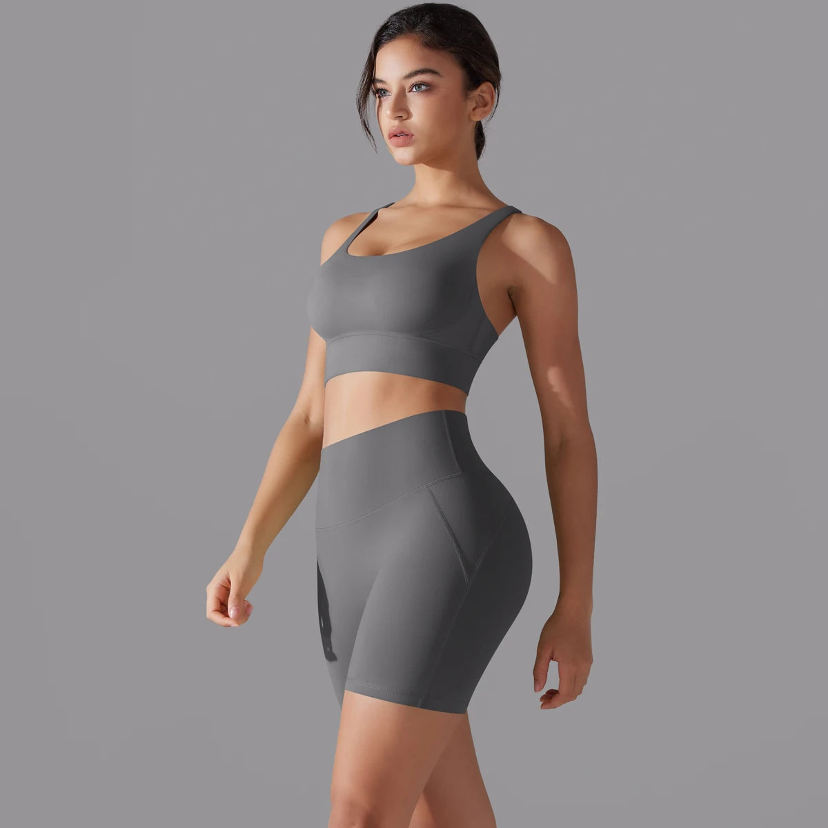 Nahtloses Fitnessset für Damen: graues Sporttop und kurze Leggings, seitlich