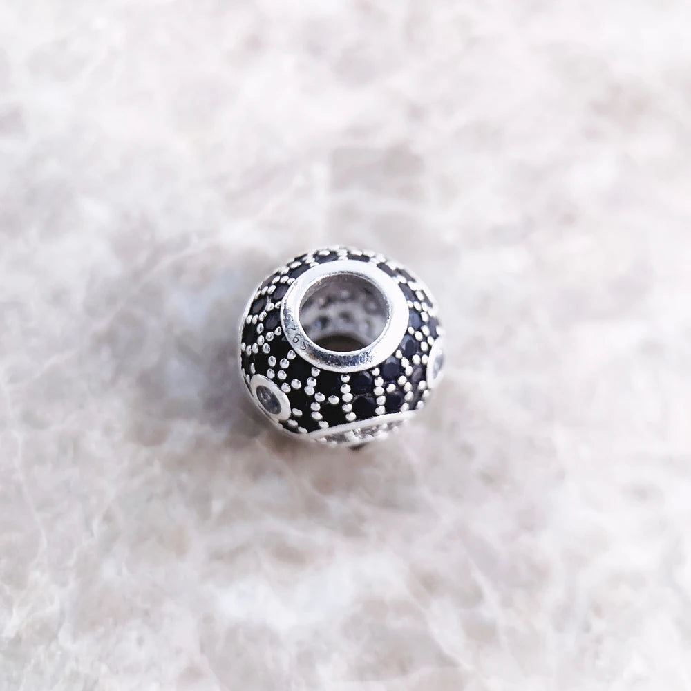 Yin-Yang-Perlen-Charms von oben: schwarzes Pave-Muster mit silberfarbener Öffnung