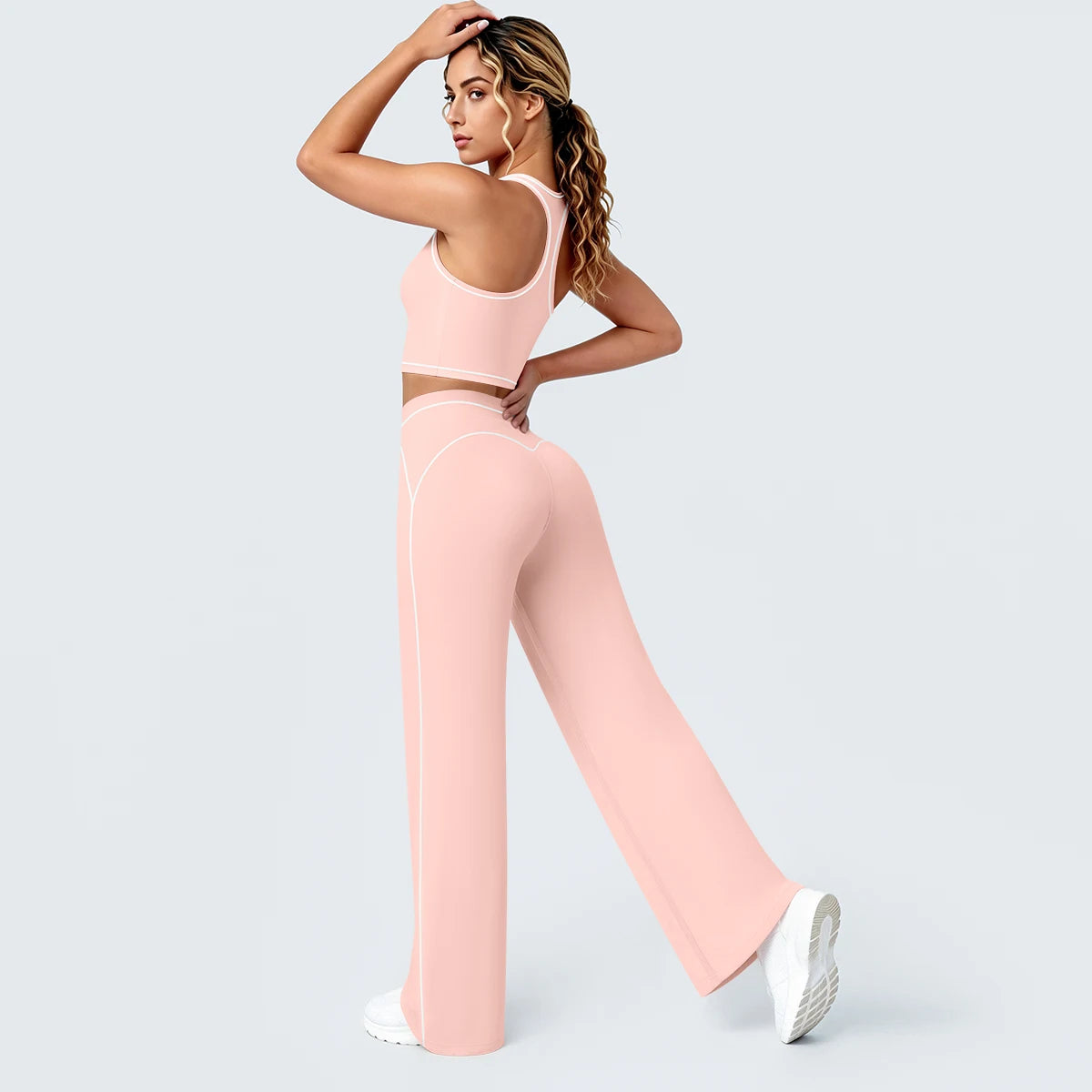Damen-Yoga-Set in Hellrosa: Tank-Top mit Kontraststreifen, weite Hose mit Linien am Bein.