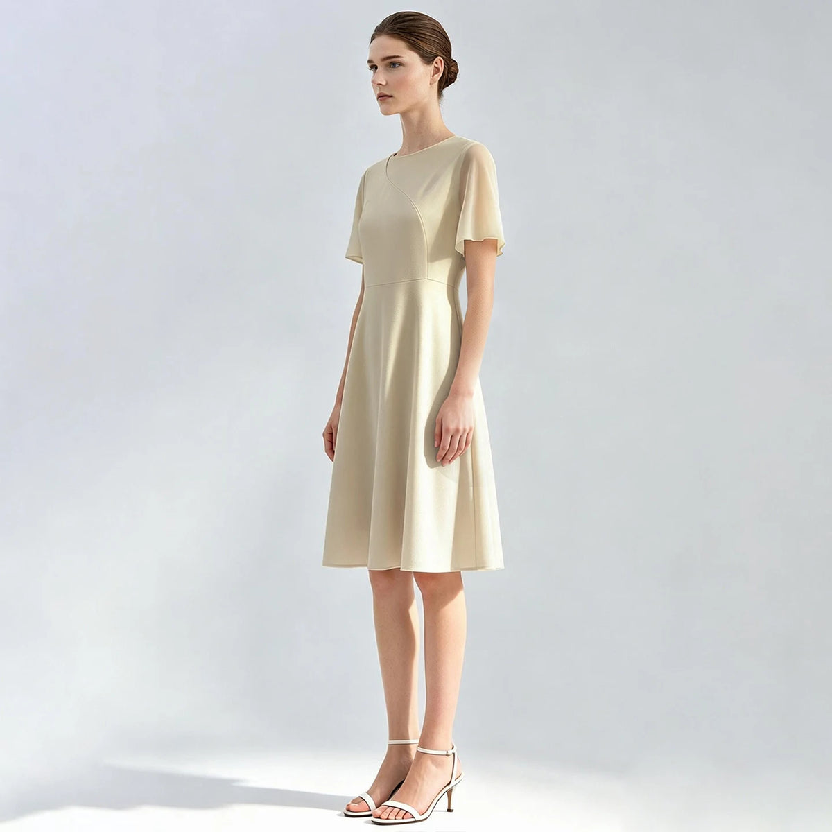 Hellbeiges tailliertes Damenkleid mit kurzen Ärmeln und gerafftem, weit fallendem Rock