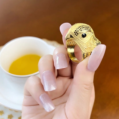Goldfarbener Cocktailring mit Eulenkopf und schwarzem Augeinsatz, auf Hand