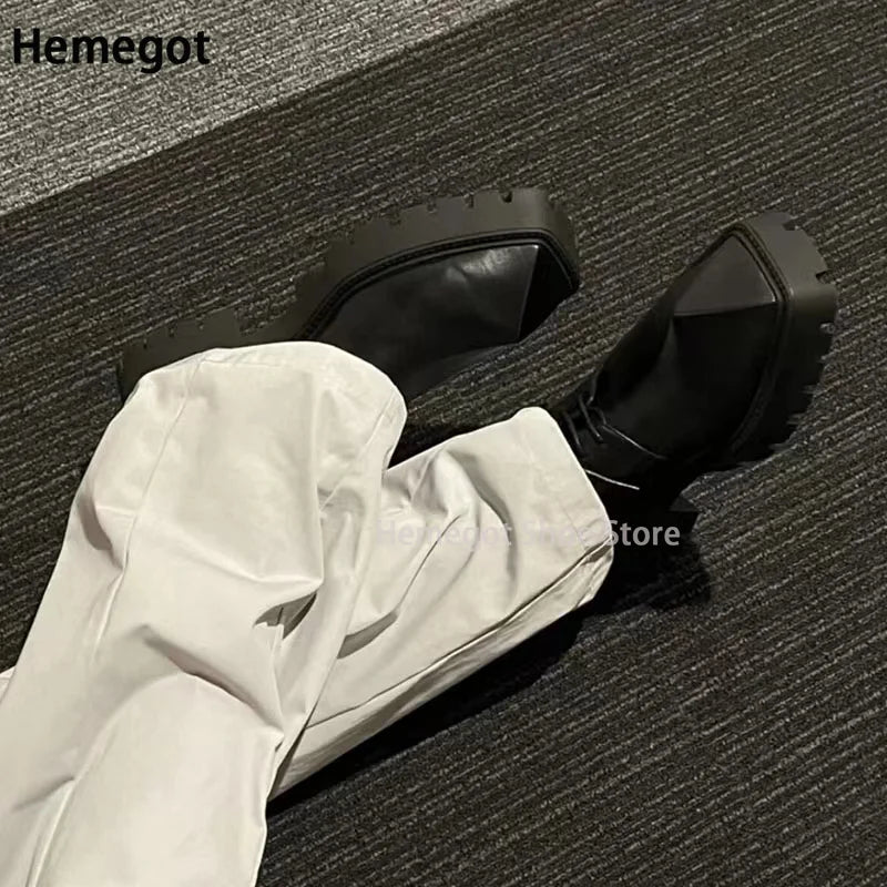 Schwarze Derby-Schuhe mit Schnürung und Profilsohle, neben heller Hose