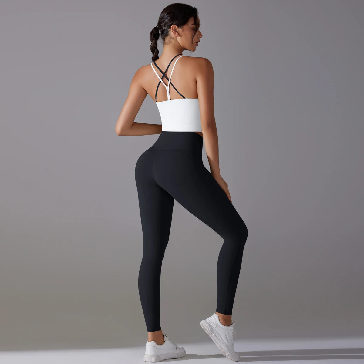 Schwarzes Yoga-Set seitlich: weißer Sport-BH, Leggings mit nahtlosem Look