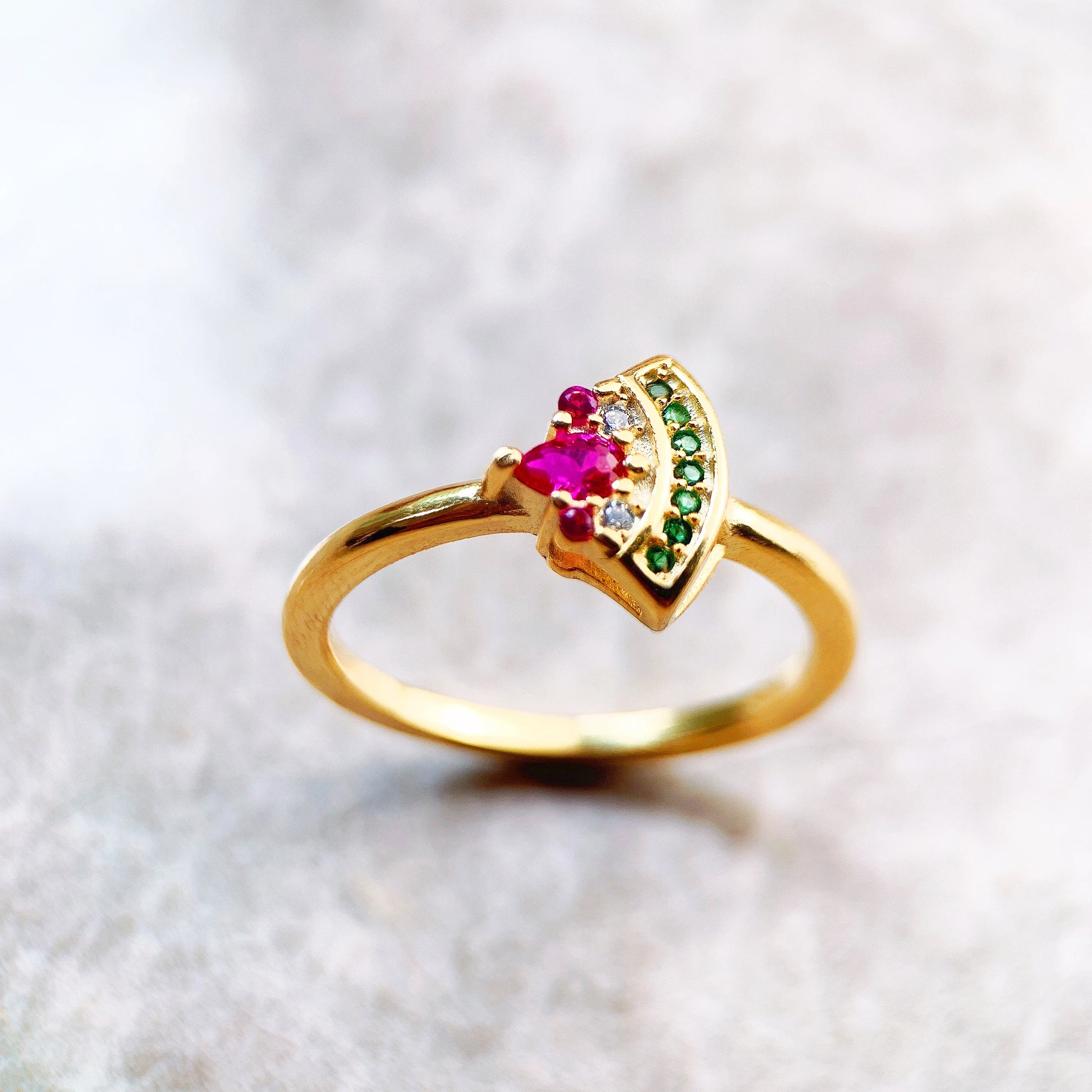 Goldfarbener Ring aus 925er Sterlingsilber mit pinkem Stein und grüner Zackenfassung