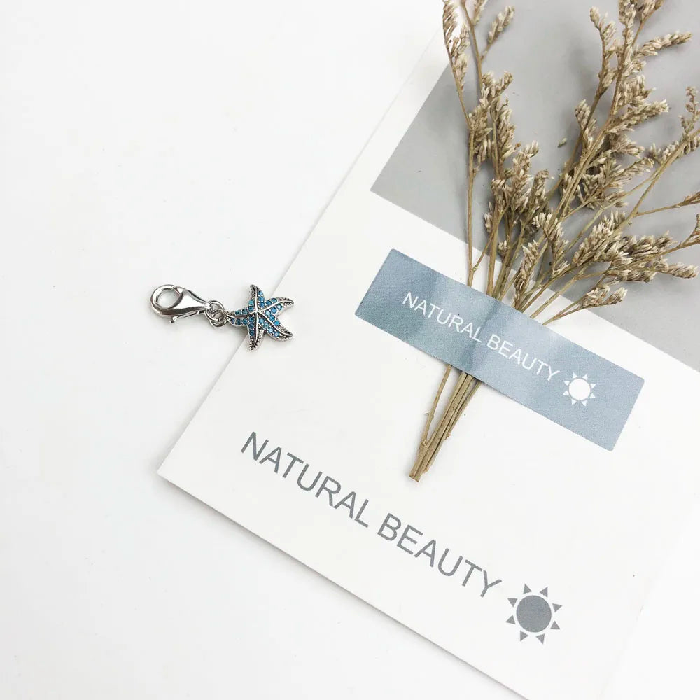 Seestern-Anhänger mit blauen Details und Öse, auf Karten mit Anhängerablage