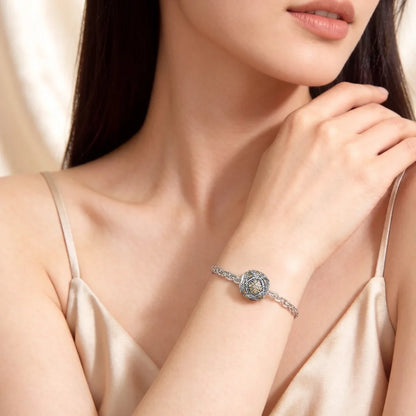 Silberner Karma-Charms am Armband: rundes Design mit funkelnden Steinen