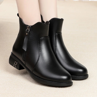 Schwarze Stiefelette am Fuß mit Reißverschluss und kurzem Blockabsatz.