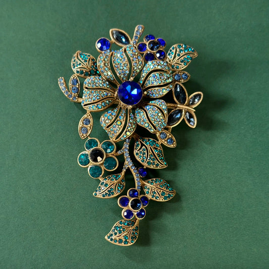 Brosche in Blumenform mit blauem Kristall und goldfarbenem Rahmen