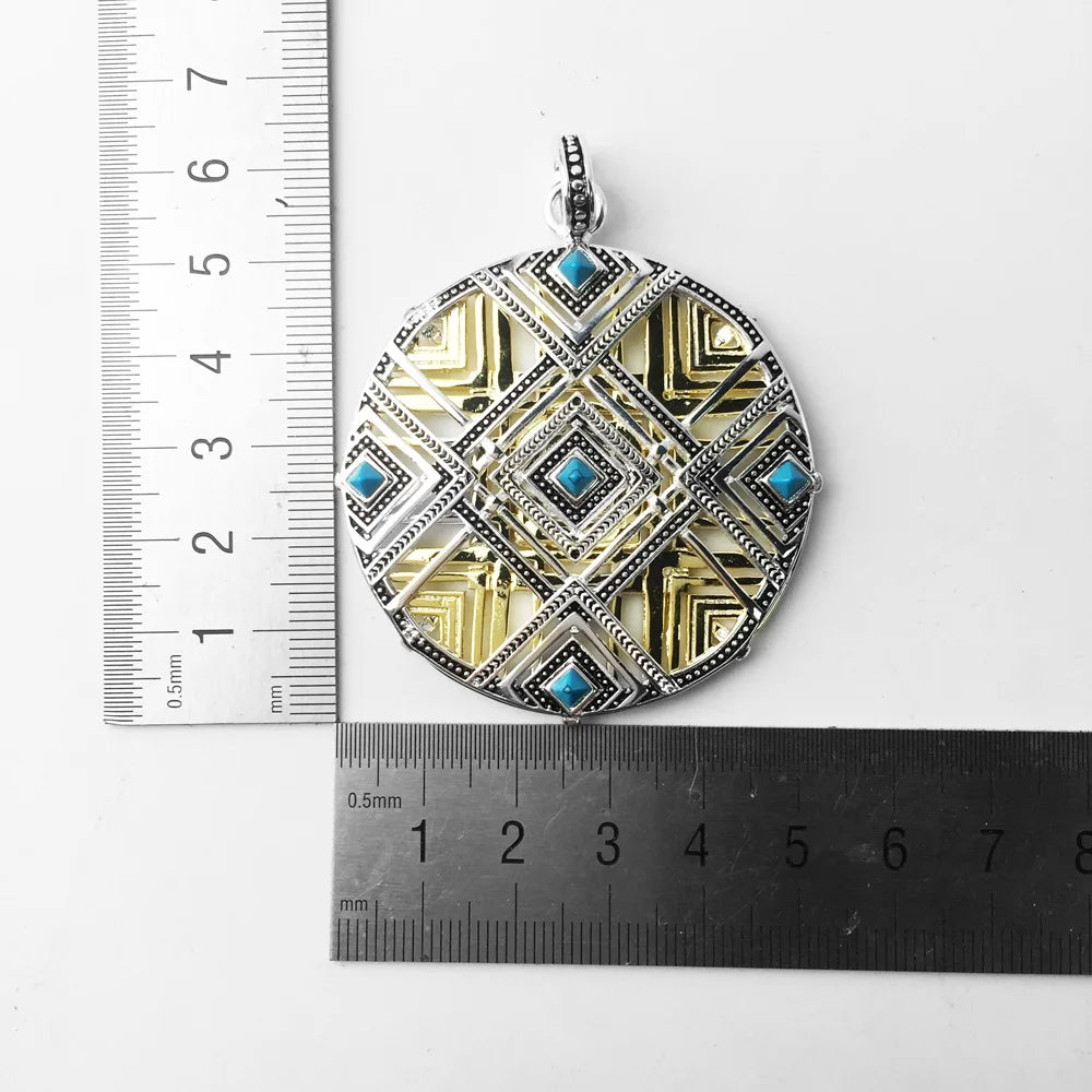 Runder Anhänger mit goldfarbener Oberfläche, geometrischem Muster und blauen Einsatzsteinen