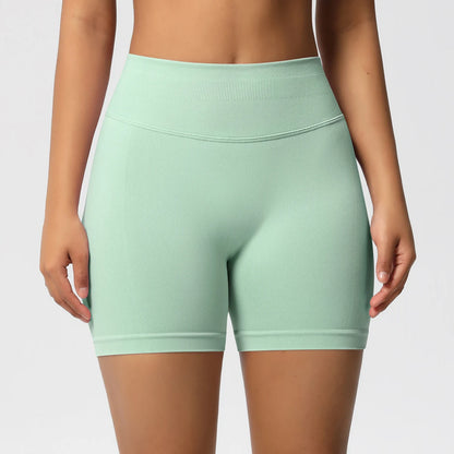 Hohe taillierte Sportshorts, hellgrün, eng geschnitten, mit breitem Bund vorne.
