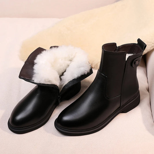 Schwarze Kurzstiefeletten aus Leder mit weißem Woll-/Fellfutter und seitlicher Lasche