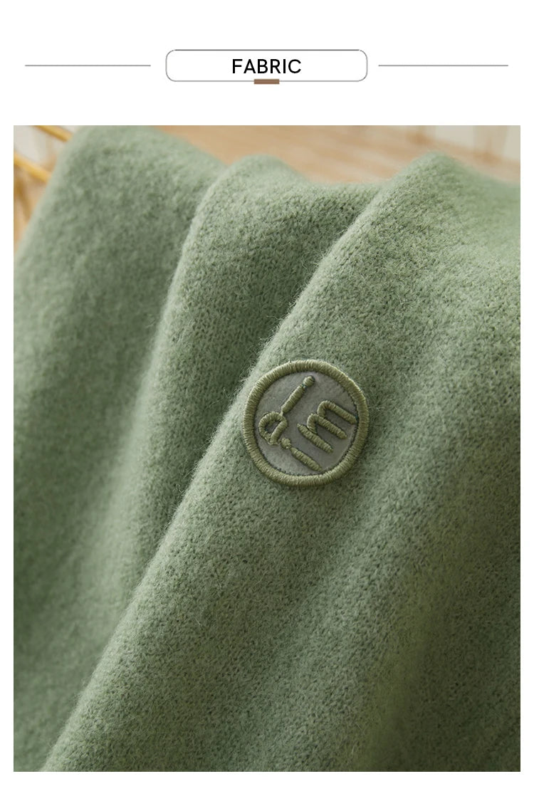 Damenpullover-Stoff in hellgrün mit gesticktem runden Emblem