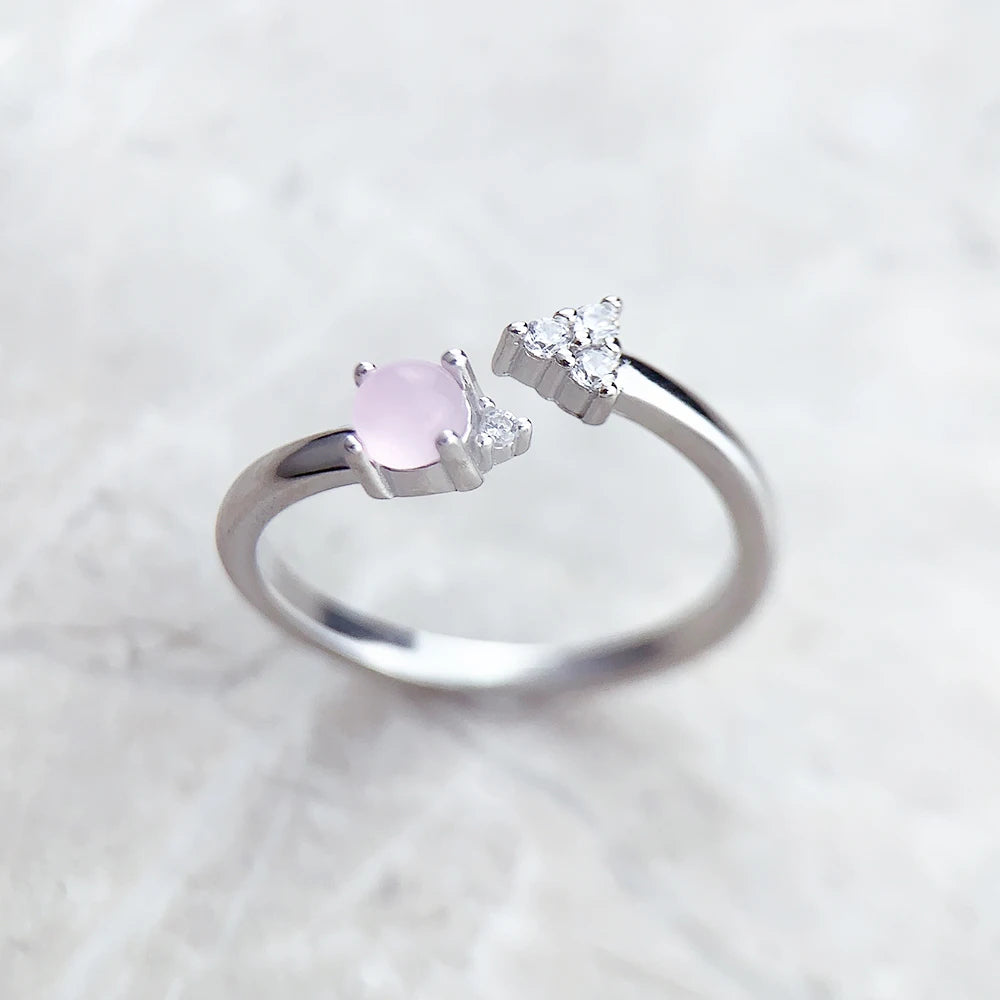 Silberner Ring mit ovalem rosafarbenem Stein in Zargenfassung und Zirkonia-Details