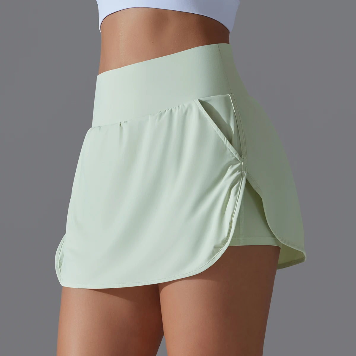 Hochtailierte Sportshorts, hellgrün, Rückansicht mit drapierter Taschenpartie