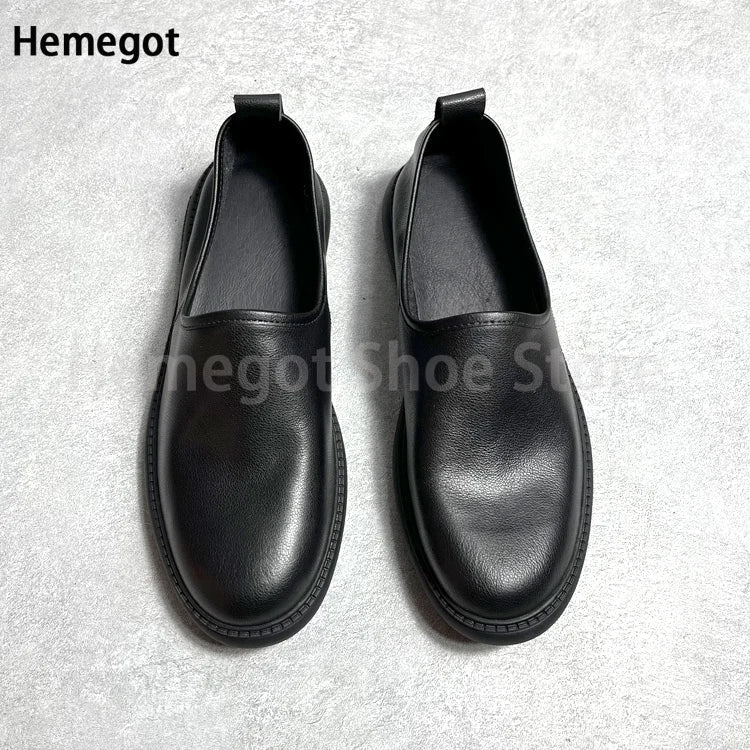 Schwarze Leder-Slip-on-Loafer im Paar von hinten, gepolsterter Schaft, flache Sohle