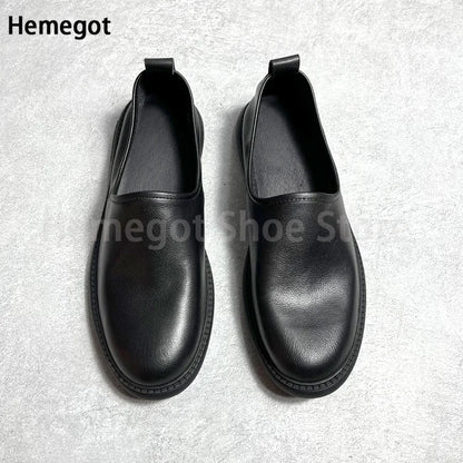 Schwarze Leder-Slip-on-Loafer im Paar von hinten, gepolsterter Schaft, flache Sohle