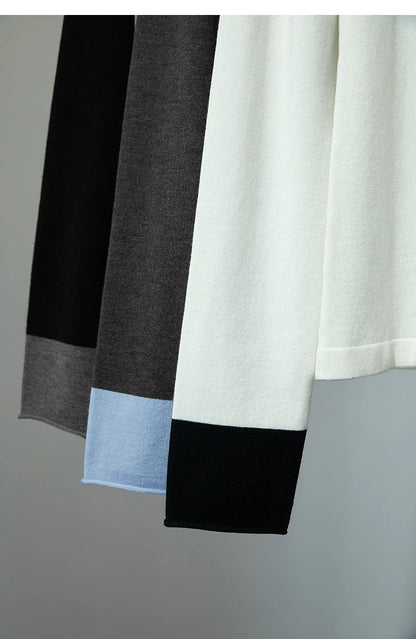 Strickpullover mit farblich abgesetztem Saum: weißer Körper, schwarzer Abschluss und blauer Streifen